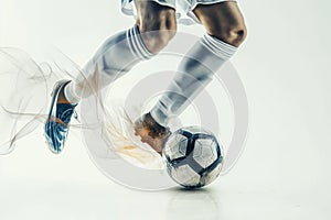 A soccer player dribbles and kicks a ball on a field