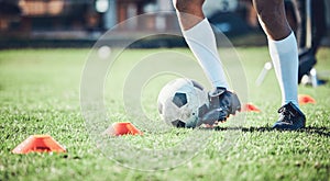 Soccer player, feet and ball with training cone on a field for sports game and fitness. Legs or shoes of male football