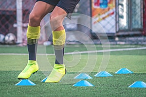 Soccer player feet training with marker in soccer academy field