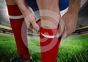 soccer player in the field putting well his red shocks