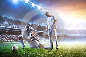 Soccer player helps onother one on sunset stadium background panorama