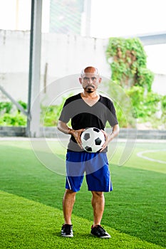Soccer player holding ball in hands