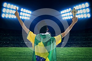 Soccer player holding trophy at field