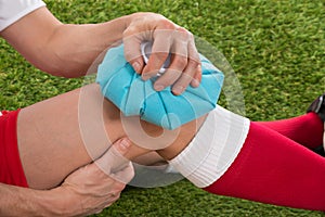 Soccer player icing knee with ice pack