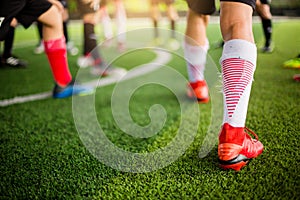 Soccer player Jogging on green artificial turf and stretching their feet. warming up the body and foot