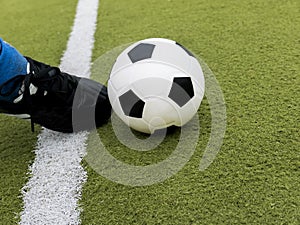 Soccer player kick the ball on football stadium field