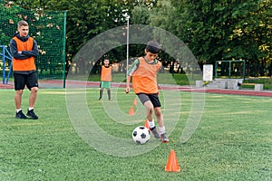 Soccer player kicking ball on field. Soccer players on training session. Teen footballer kicking ball on green grass.