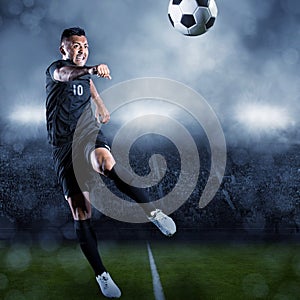 Soccer player kicking ball in a large stadium