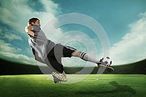 Giocatore scavando palla da calcio medio l'aria stadio il cielo 