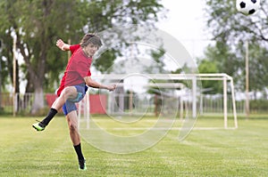 Soccer player kicks ball in a field photo