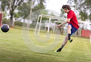 Soccer player kicks ball in a field photo