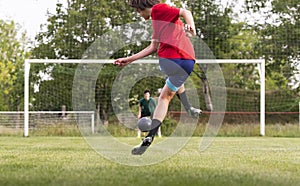 Soccer player kicks ball in a field