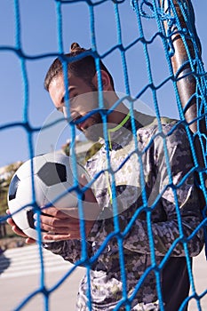 Soccer player looking football ball in his hands