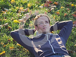 Soccer Player Lying in the Grass with Football