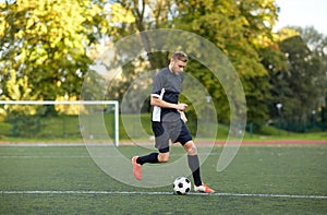 Soccer player playing with ball on football field