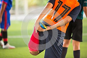 Soccer player is stretching their hands to catch their feet