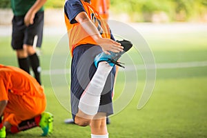 Soccer player is stretching their hands to catch their feet