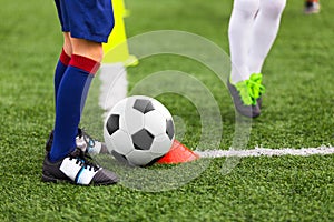 Soccer Player With White and Black Football Ball in a Corner. Young Athlete Kicking Ball on Grass Field