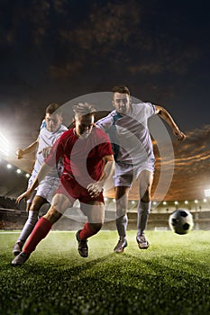 Soccer players in action on sunset stadium background