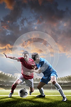 Soccer players in action on sunset stadium background