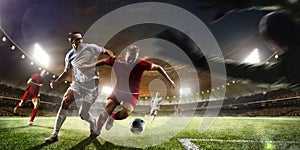 Soccer players in action on sunset stadium background panorama photo