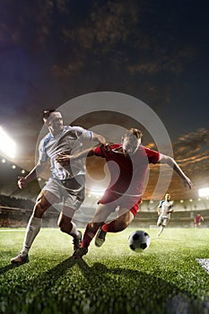 Soccer players in action on sunset stadium background