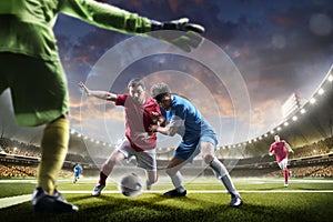 Soccer players in action on sunset stadium background panorama