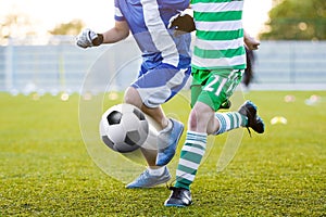 Soccer players kicking soccer ball on sports venue. European foo