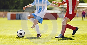 Soccer players in red and blue shirts at duel. Youth football tournament game