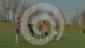 Soccer players training football in the pitch