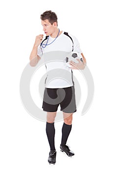 Soccer referee holding football