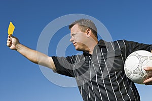 Soccer referee holding yellow card