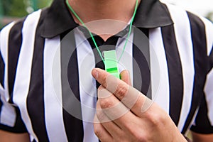 Soccer referee holds whistle at hand photo