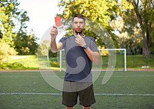 soccer referee with whistle showing red card