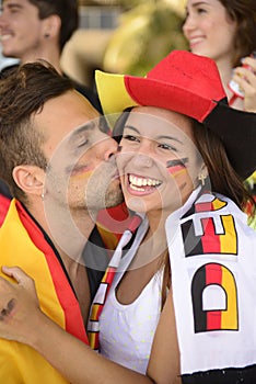 Soccer sport fans kissing.