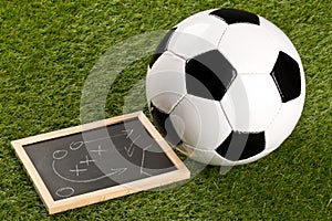 Soccer sports ball with game strategy drawing blackboard on grass background