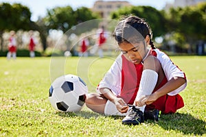 Soccer, sports and girl tie her shoes in training practice for fitness, wellness and youth development. Exercise