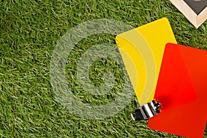 Soccer sports referee chrome whistle with game strategy drawing blackboard and yellow and red referee cards on grass background