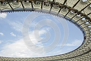 Soccer stadium inside view. football field, empty stands, a crowd of fans, a roof against the sky