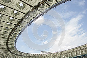 Soccer stadium inside view. football field, empty stands, a crowd of fans, a roof against the sky