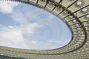 Soccer stadium inside view. football field, empty stands, a crowd of fans, a roof against the sky