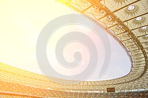 Soccer stadium inside view. football field, empty stands, a crowd of fans, a roof against the sky