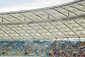 soccer stadium inside view. football field, empty stands, a crowd of fans, a roof against the sky