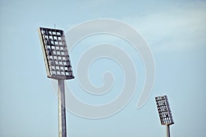 Soccer stadium lights reflectors against an empty blue sky