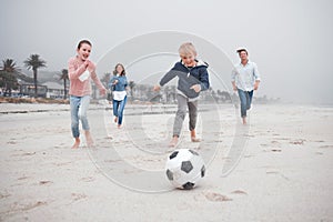 Soccer, summer beach activity and family running and playing with energy and happiness. Happy sea sport and football