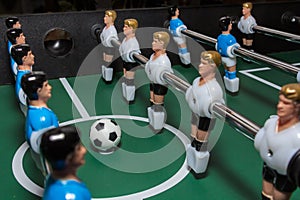 Soccer table game. Green field with blue and white plastic footballers