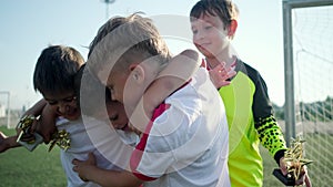 Soccer team of little boys is rejoicing by winning