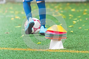 Soccer training cone equipment on green sport field for football academy and youth sport concept