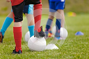 Soccer training drill for kids. Legs of football players attending soccer class. Children playing sports outdoor. School kids in