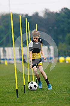 Soccer Training Drill For Youth Junior Player. Young Teenage Boy Running and Dribbling Ball Between Training Poles